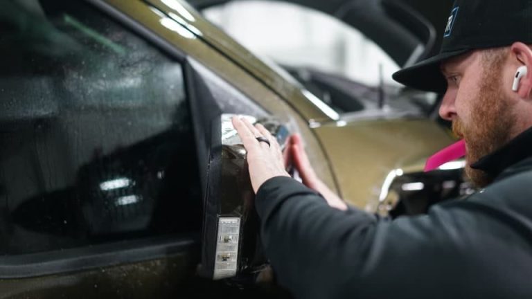 Ben at Tabula Rasa applying paint protection film to a Ford Raptor mirror